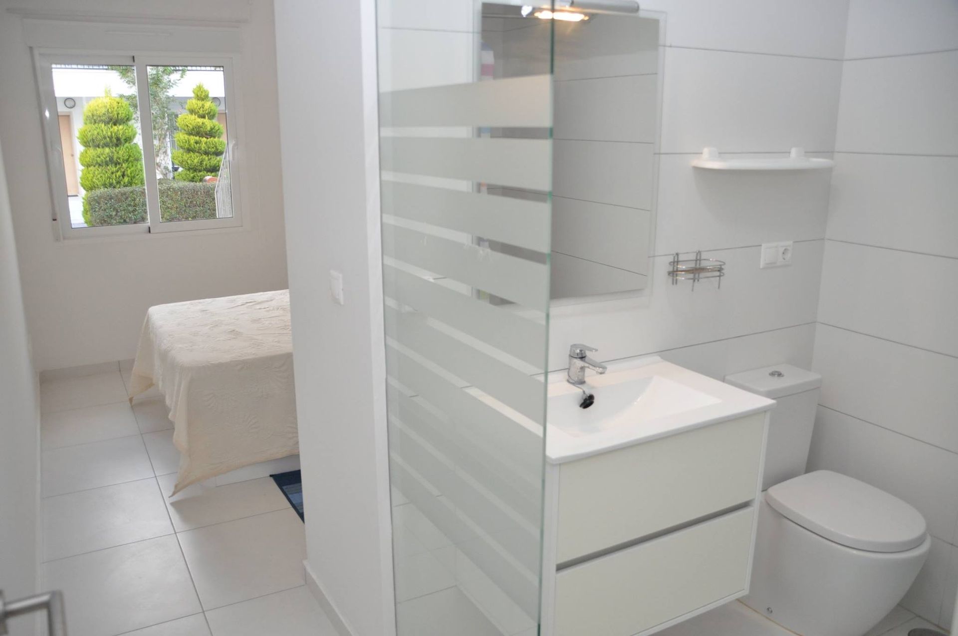 Un baño con inodoro, lavabo y ducha.