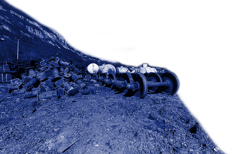 Éléments métalliques dans les tons bleus sur une pente rocheuse abrupte avec un flanc de colline boisé en arrière-plan