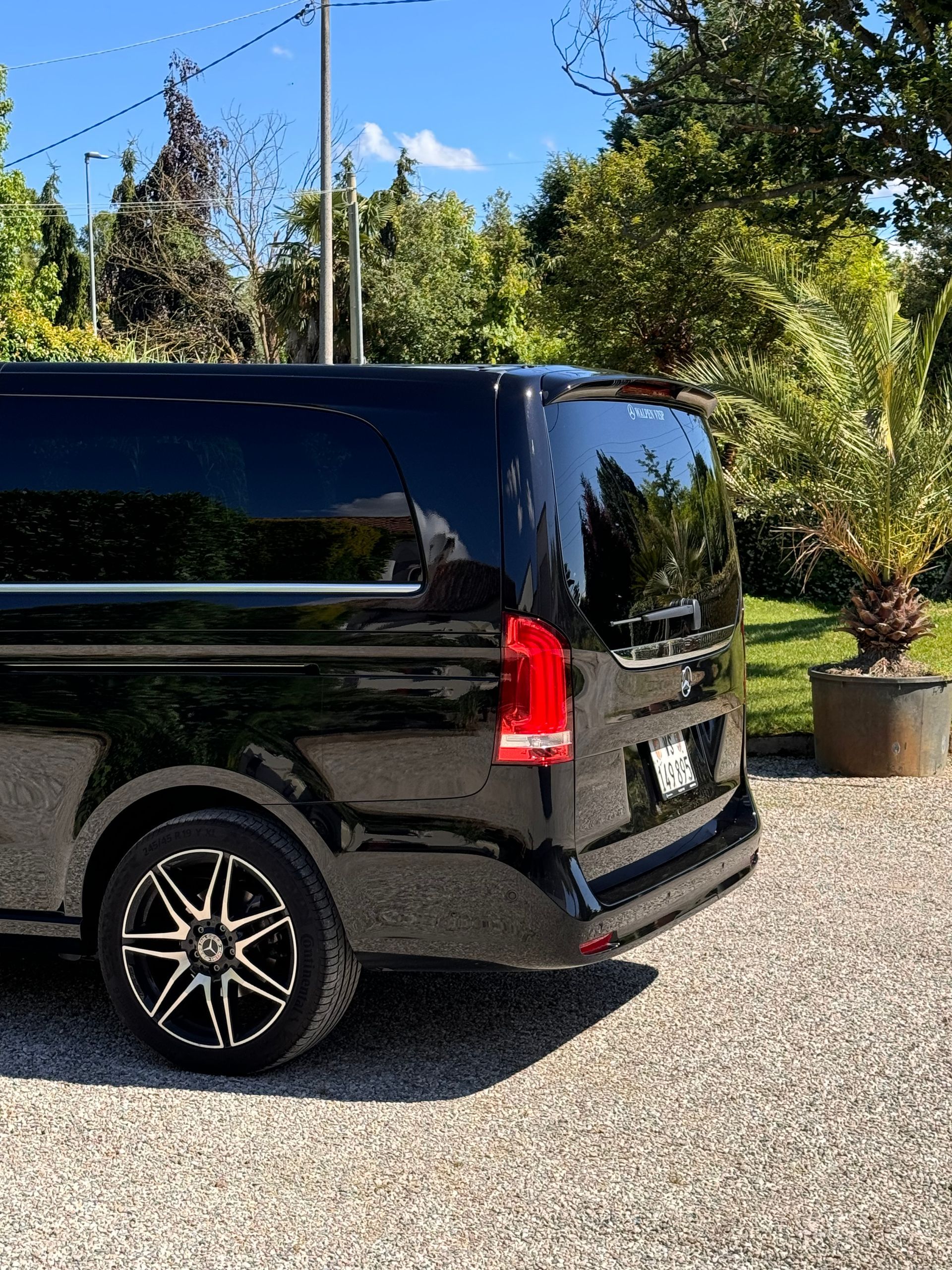 Une camionnette Mercedes-Benz Sprinter noire garée sur une route goudronnée.