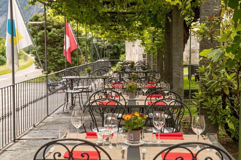 Un patio con tavoli e sedie per un pasto sotto un albero.