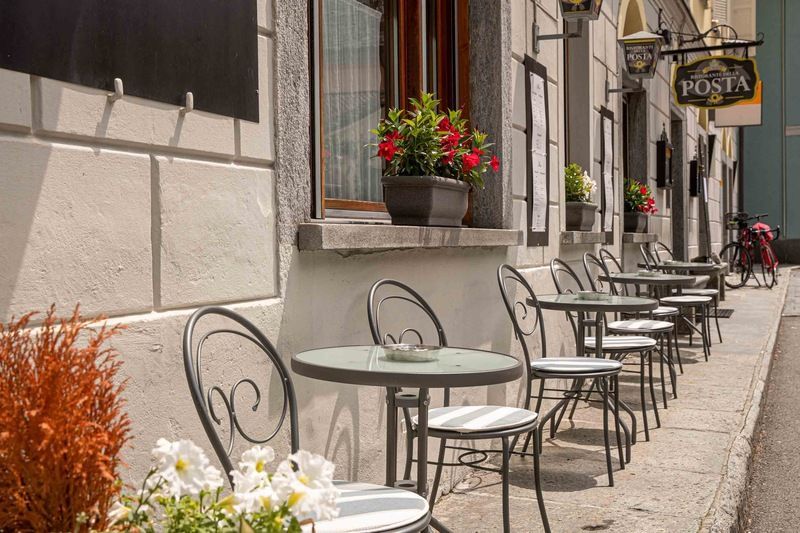 Una fila di tavoli e sedie all'esterno di un edificio.