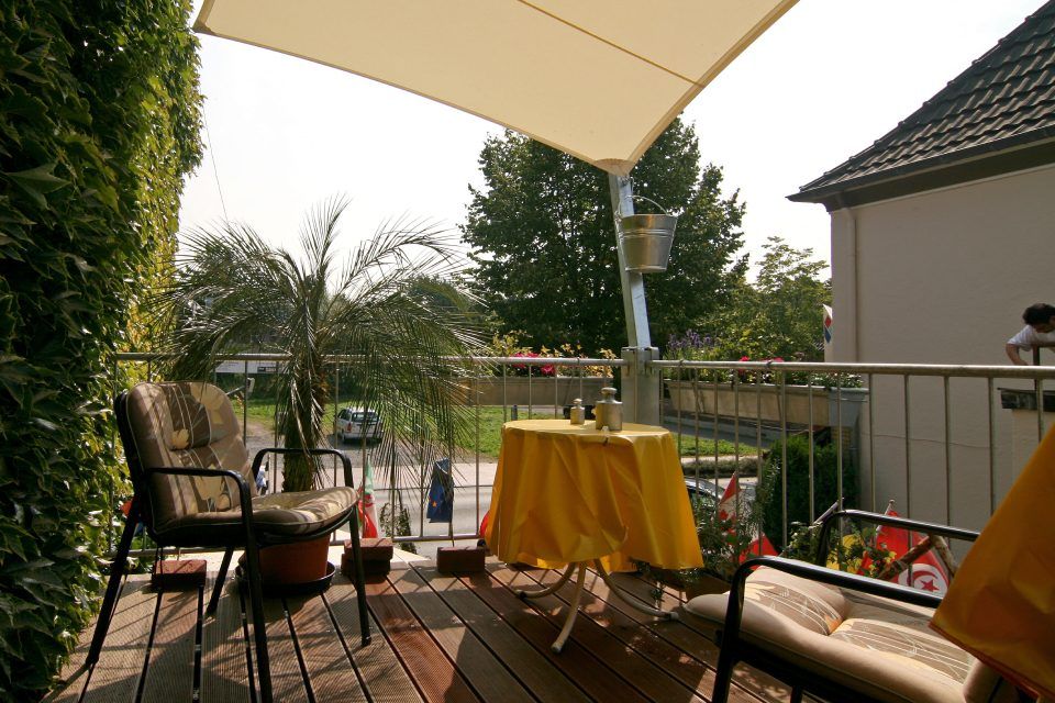 Terrasse mit kleinem Tisch, zwei Stühlen und Palme der Pension Traumstation Niederrhein Inh. Gerd Gärtner