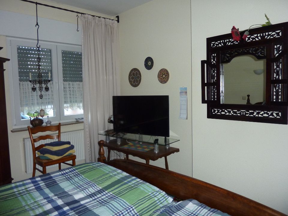 Doppelzimmer von Traumstation Niederrhein Inh. Gerd Gärtner mit Bett, Stuhl, Fernseher und Spiege