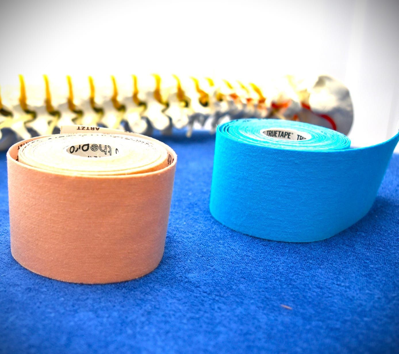 Zwei Rollen Kinesiotape auf einem blauen Tuch