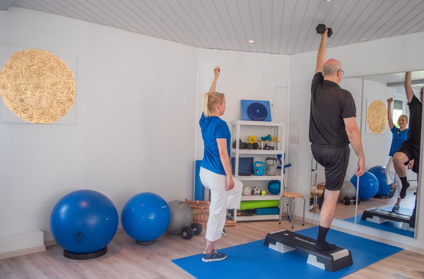 Ein Mann und eine Frau machen Übungen in einem Fitnessstudio.