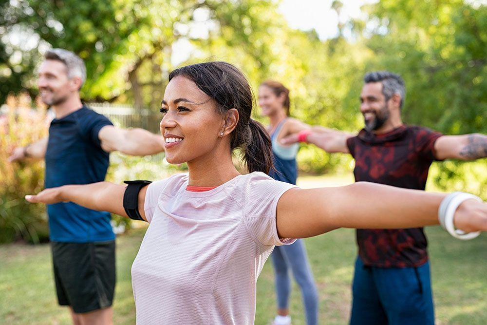 Eine Gruppe von Leuten praktiziert Yoga in einem Park.