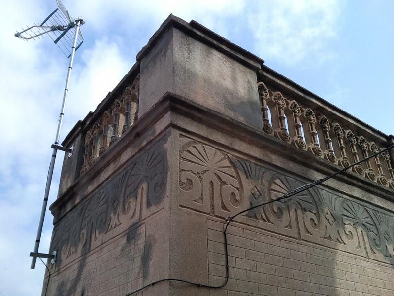 Un edifici amb un balcó i una antena a sobre