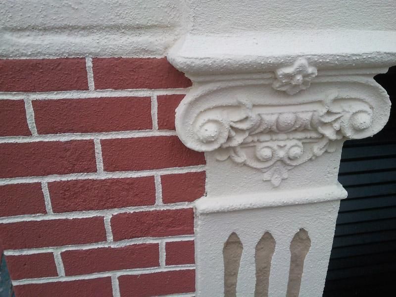 Una paret de maons amb una columna blanca