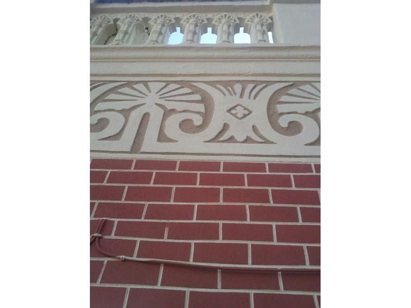 Una paret de maó vermell amb un disseny blanc