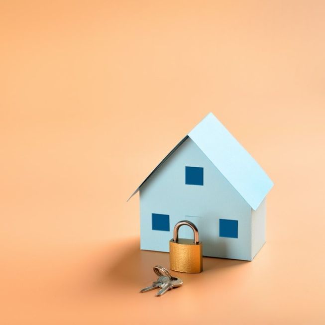 Una casa en miniatura amb un cadenat i claus al davant