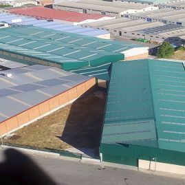Una vista aérea de una gran zona industrial con muchos edificios y techos verdes.