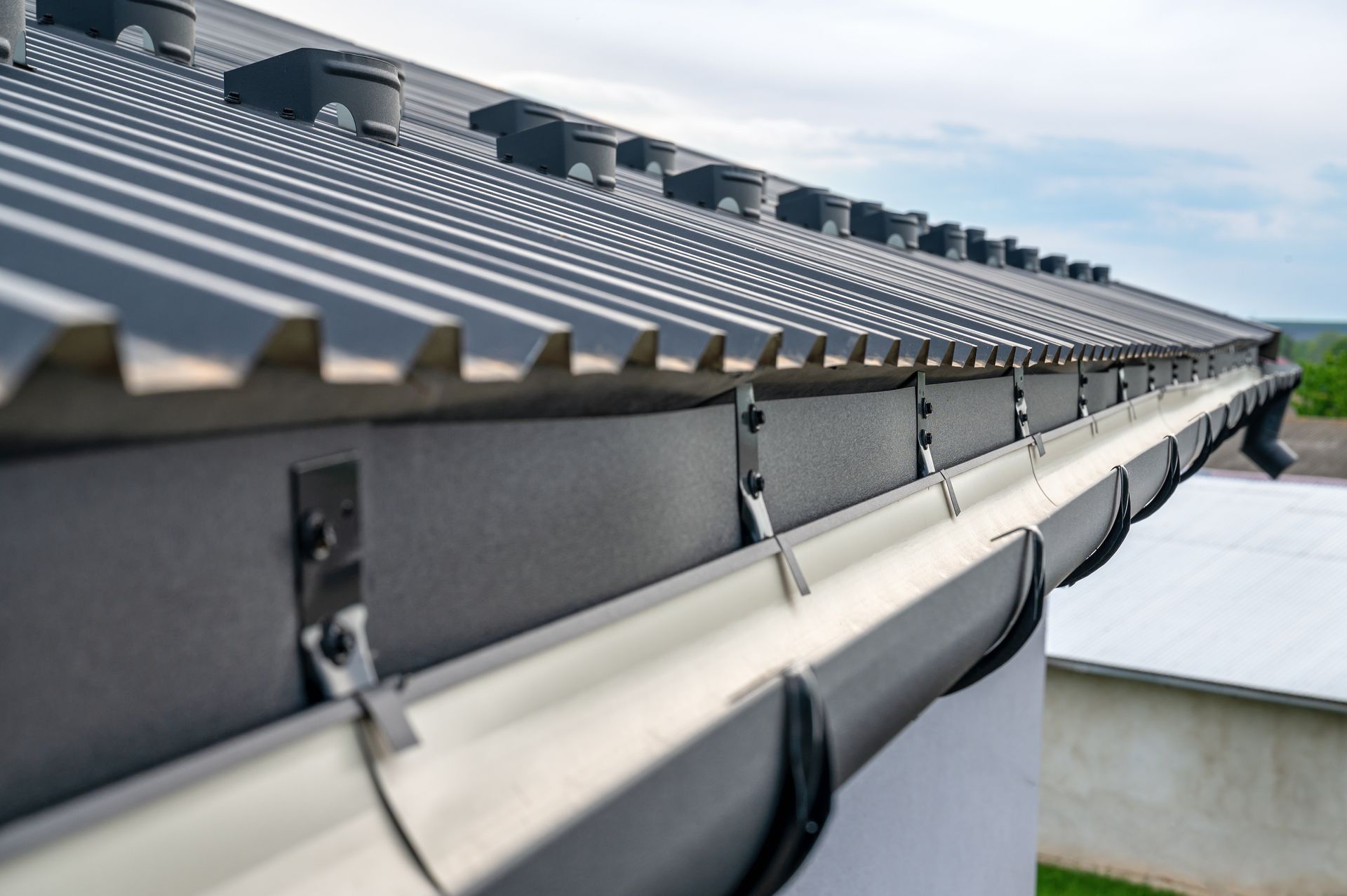 Gouttière zinc sous un toit en bac acier
