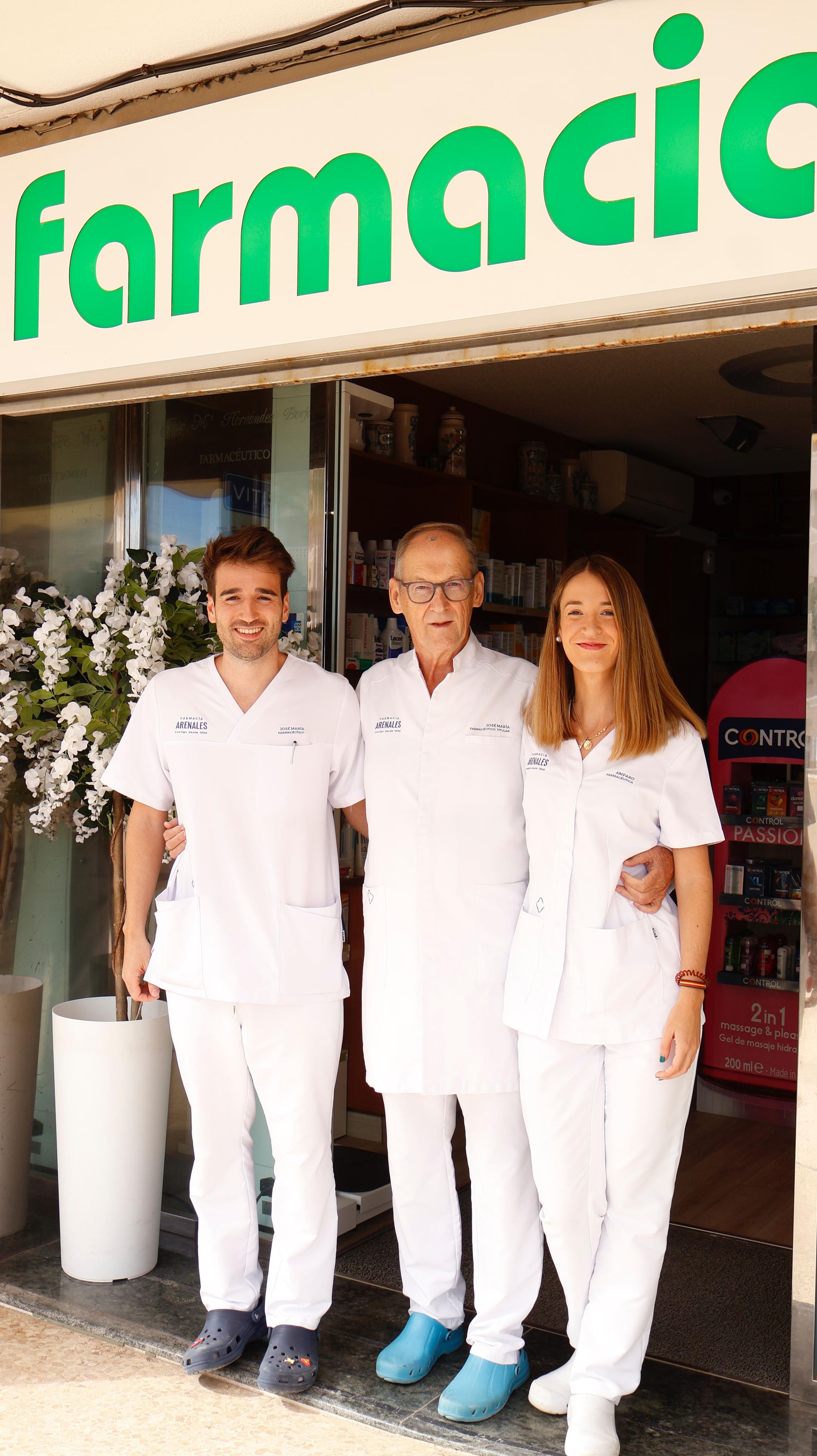 Un grupo de personas de pie frente a una farmacia.