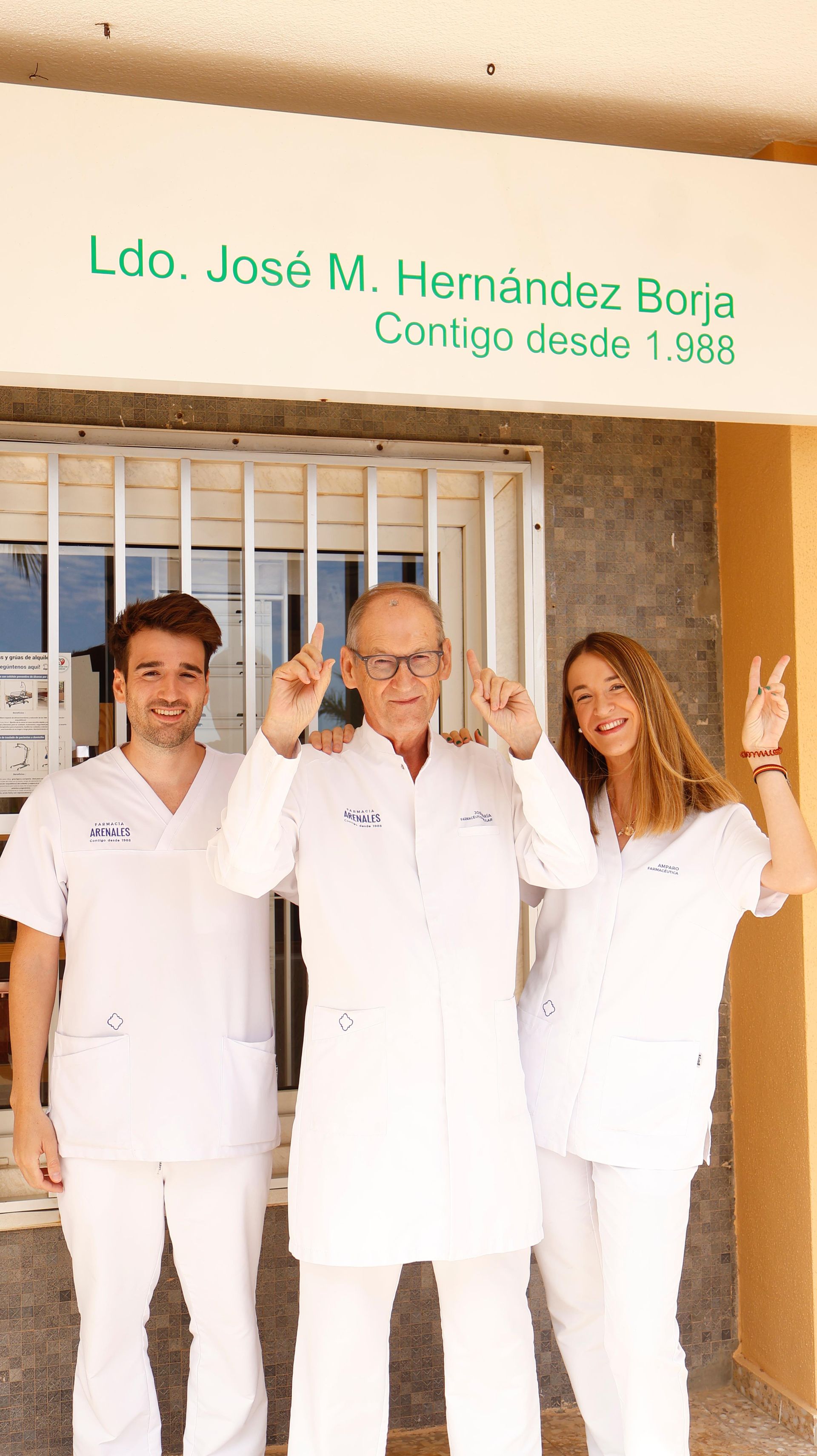 Un grupo de personas de pie frente a un cartel que dice Luc José M. Hernández Bona.