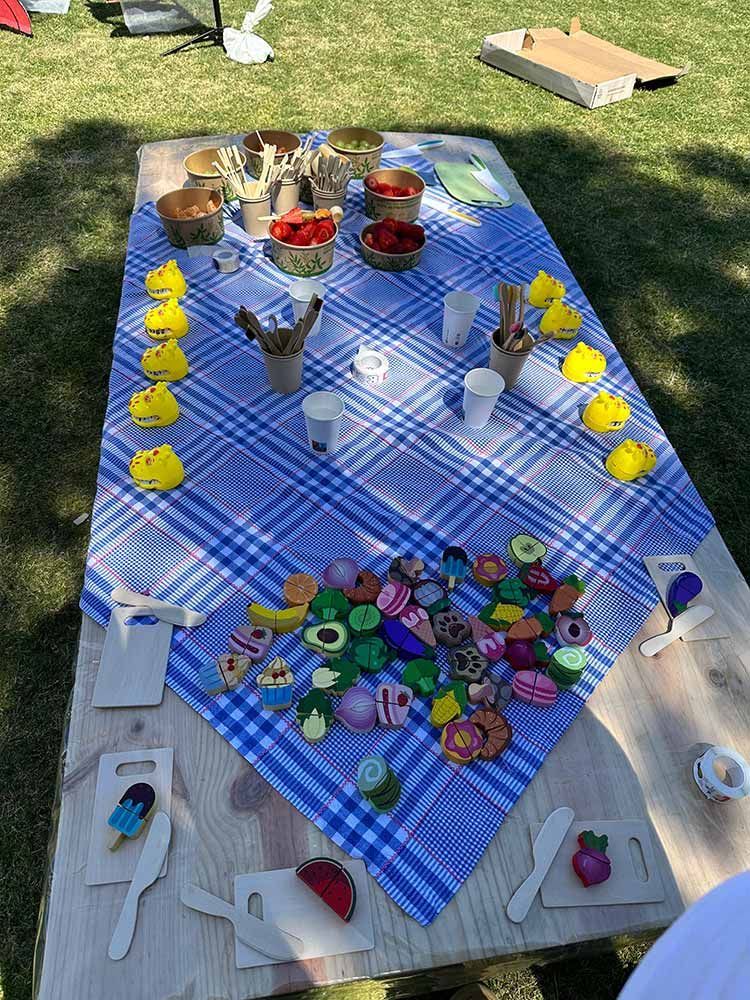 Una mesa con un mantel a cuadros azules y blancos y juguetes encima.