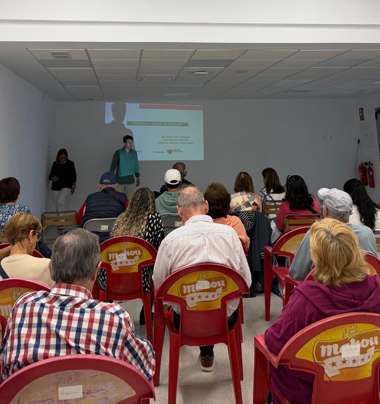 Un grupo de personas sentadas en sillas rojas con la palabra Mahou escrita en ellas.