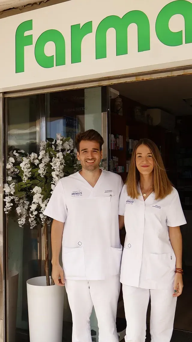 Un hombre y una mujer están parados frente a una farmacia.