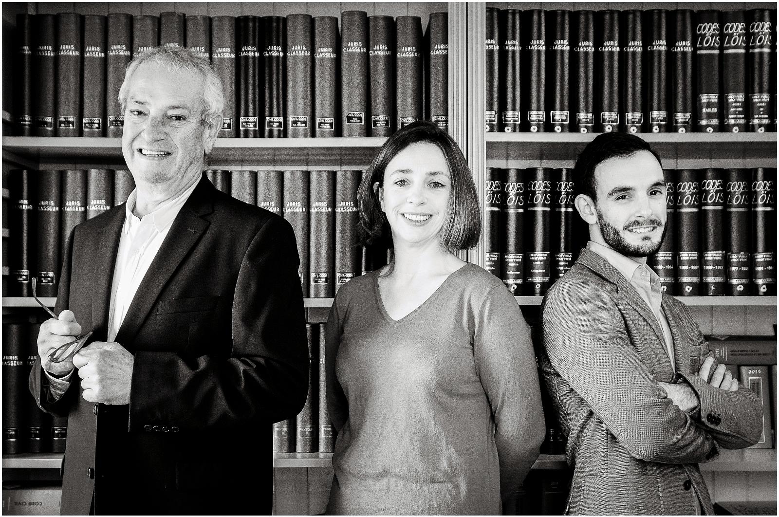 Trois avocats devant une bibliothèque