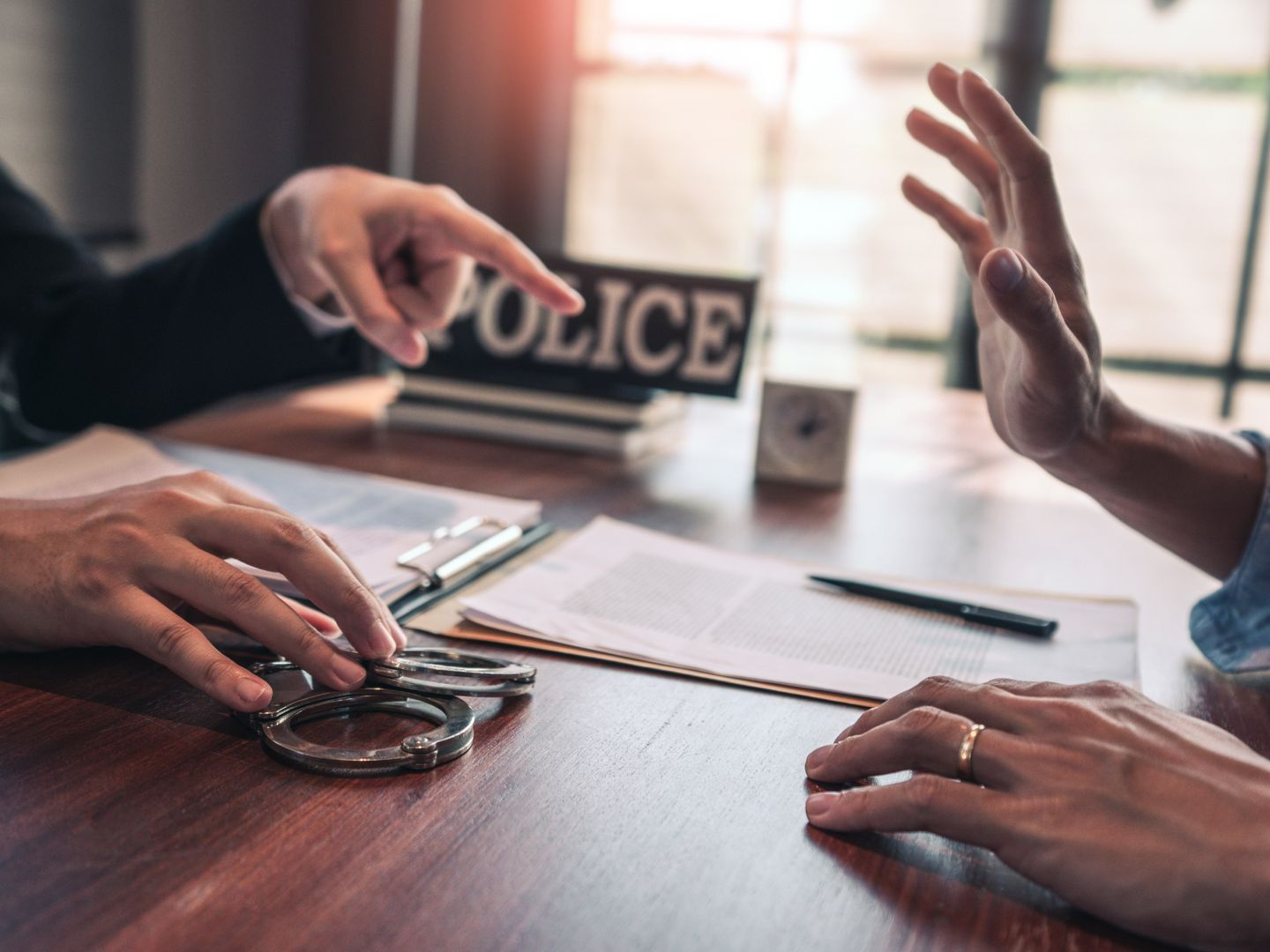 Paire de menottes sur un bureau entre deux personnes