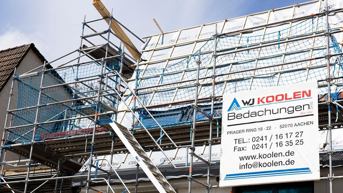 Ein Gebäude im Bau mit Gerüsten und einem Schild mit der Aufschrift „Wikolen“