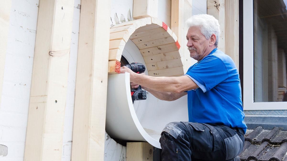 Ein Mann bearbeitet mit einer Bohrmaschine ein Stück Styropor.