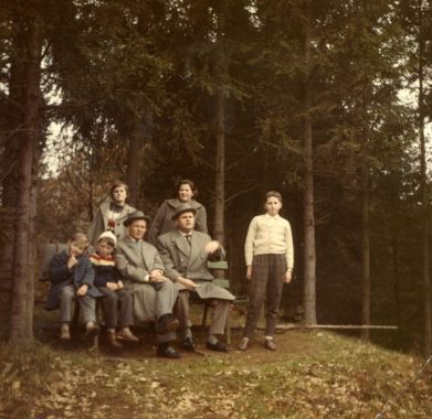 Eine Gruppe von Menschen posiert im Wald für ein Foto.