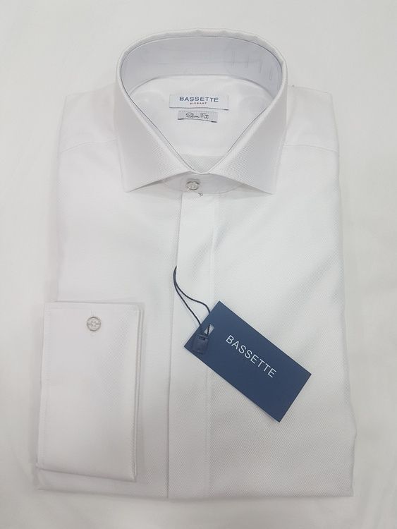 Camisa de vestir blanca, doblada, con puños franceses, etiqueta de la marca.