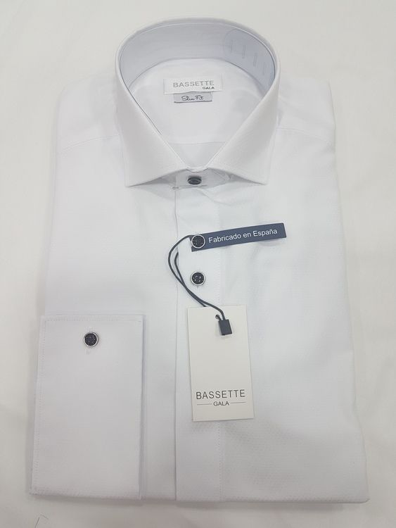 Camisa de vestir blanca, doblada, con detalles de gemelos y botones negros y etiqueta de la marca.
