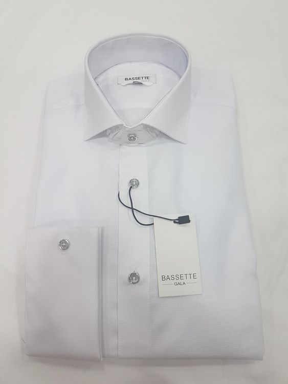 Camisa de vestir blanca, doblada, con cuello, botones y etiqueta.