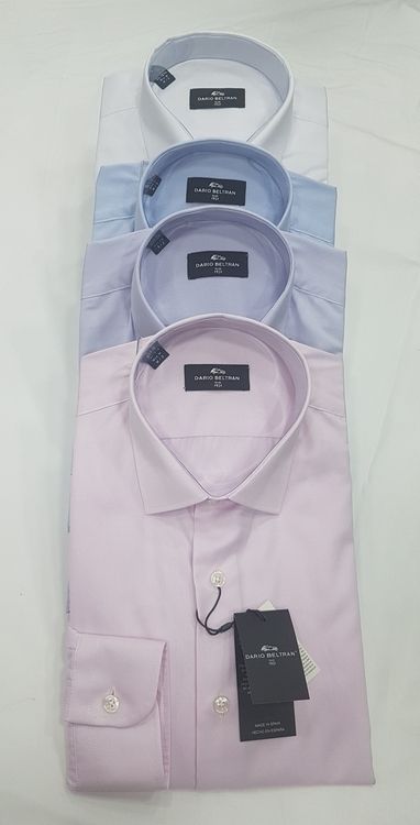 Camisas de vestir para hombre dobladas en cuatro partes: blanca, celeste, lavanda y rosa.