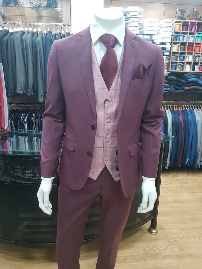 Maniquí con un traje burdeos de tres piezas en una tienda de ropa.
