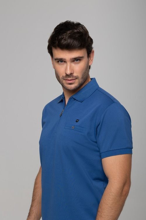 Un hombre con polo azul mira a la cámara. Tiene cabello oscuro y expresión seria.