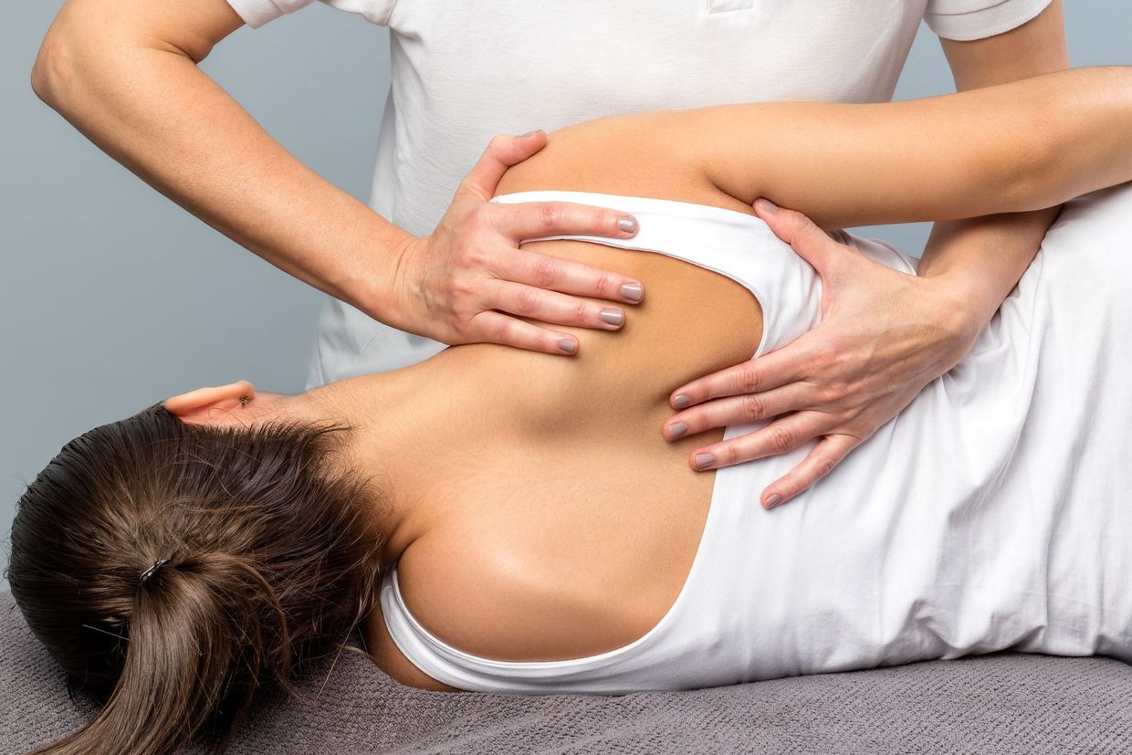 Un homme donne un massage à une femme sur un canapé.