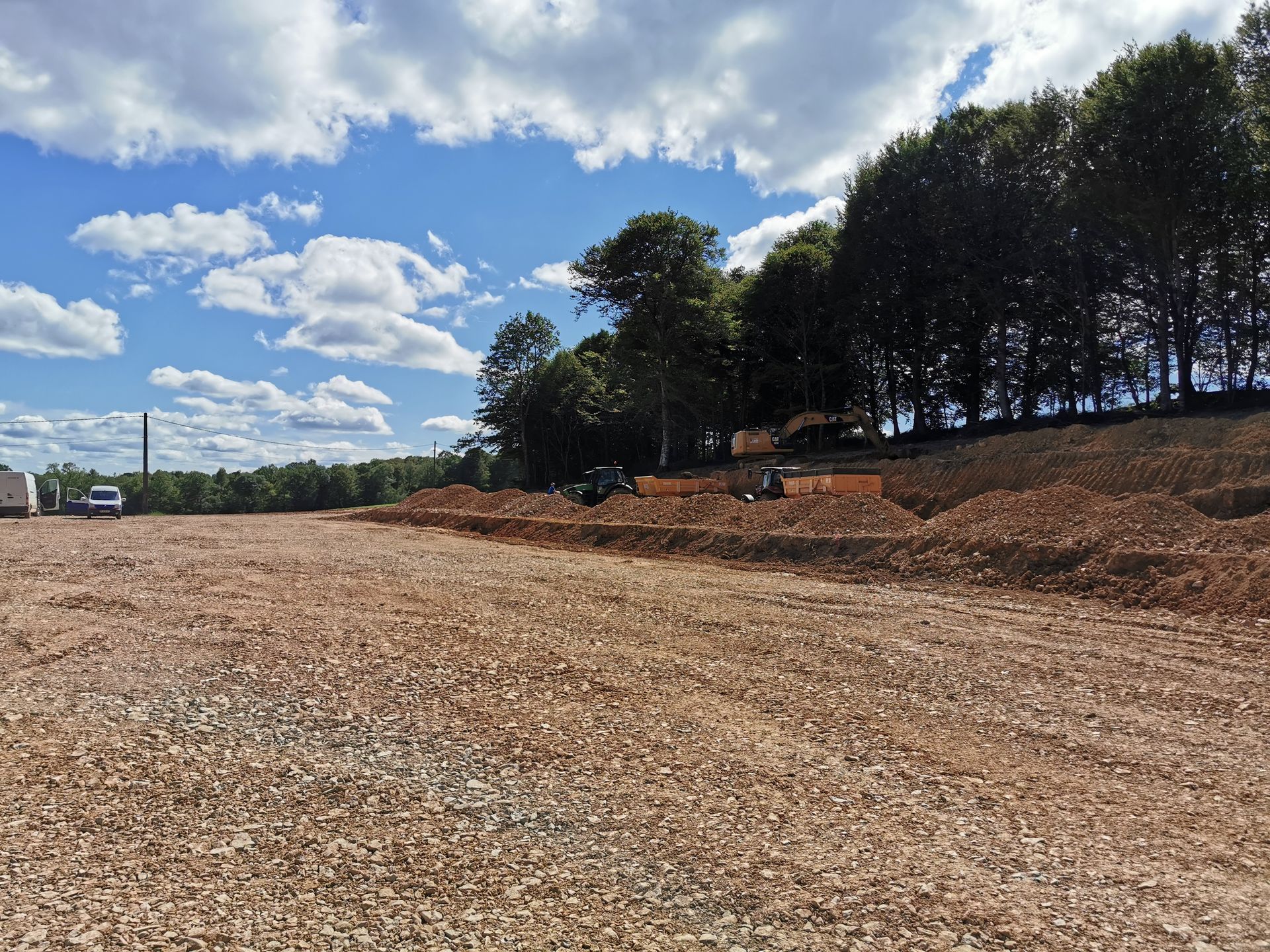 Un terrain en gravier avec des arbres.