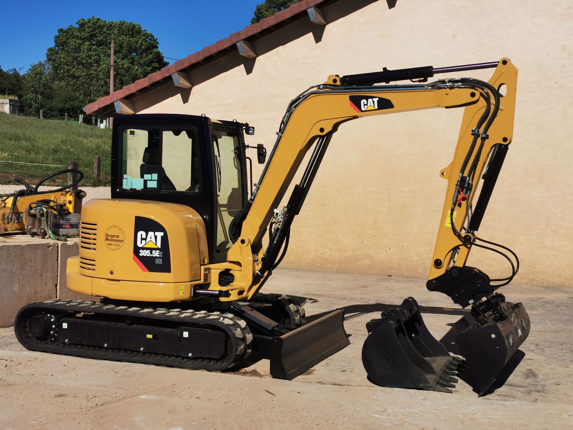 Mini-pelle Caterpillar jaune sur un chantier de construction.