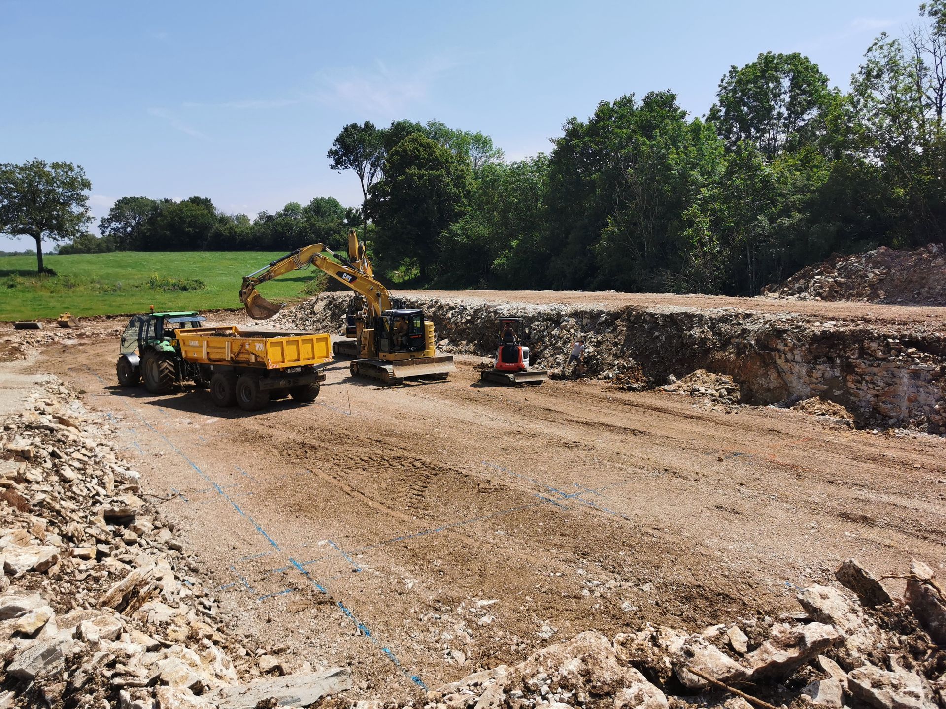 Chantier d'excavation avec une excavatrice chargeant un camion.