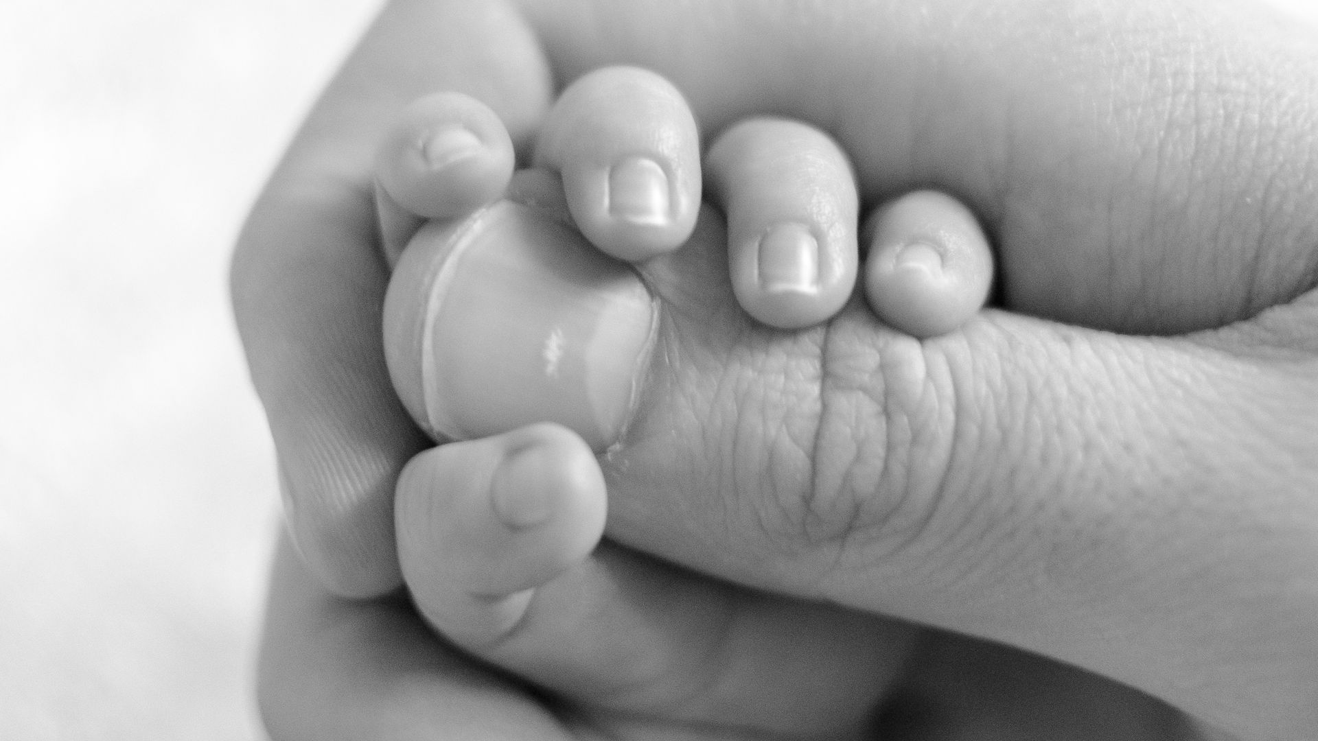 Un bébé tenant un pouce.