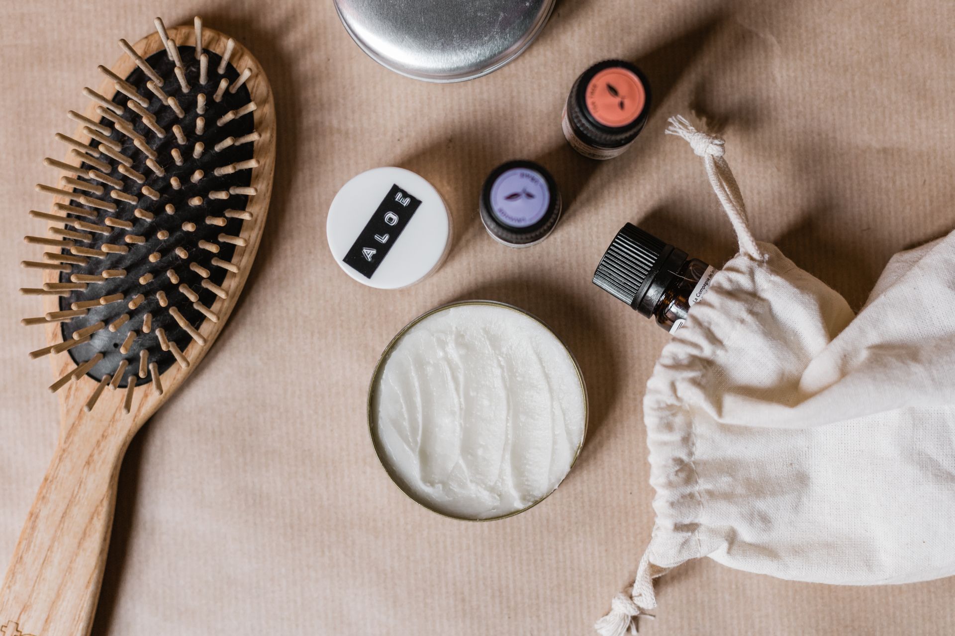 Des produits cosmétiques posés sur un tissu beige.