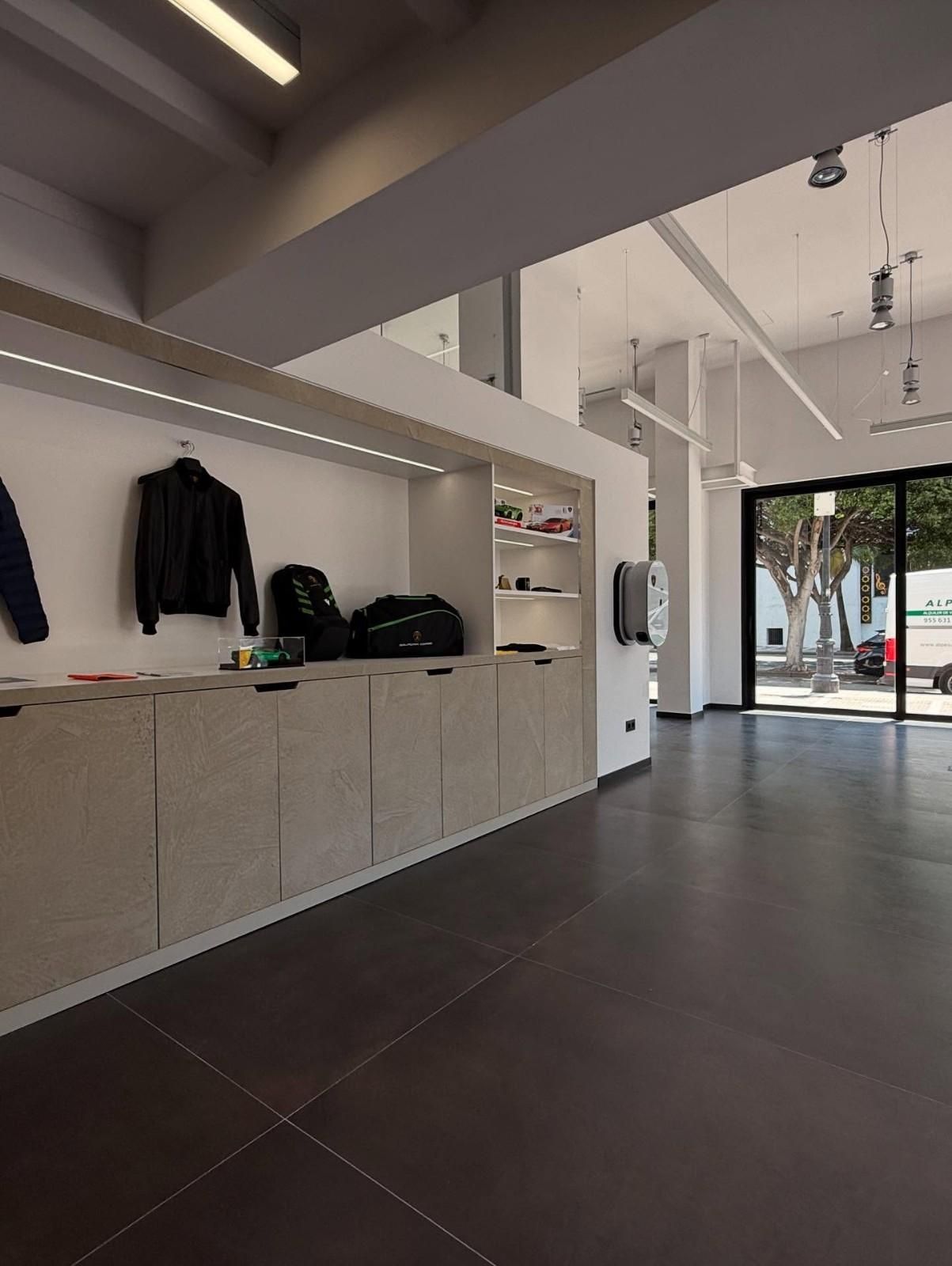 Vestíbulo moderno con armarios empotrados, percheros y puertas de entrada de cristal.
