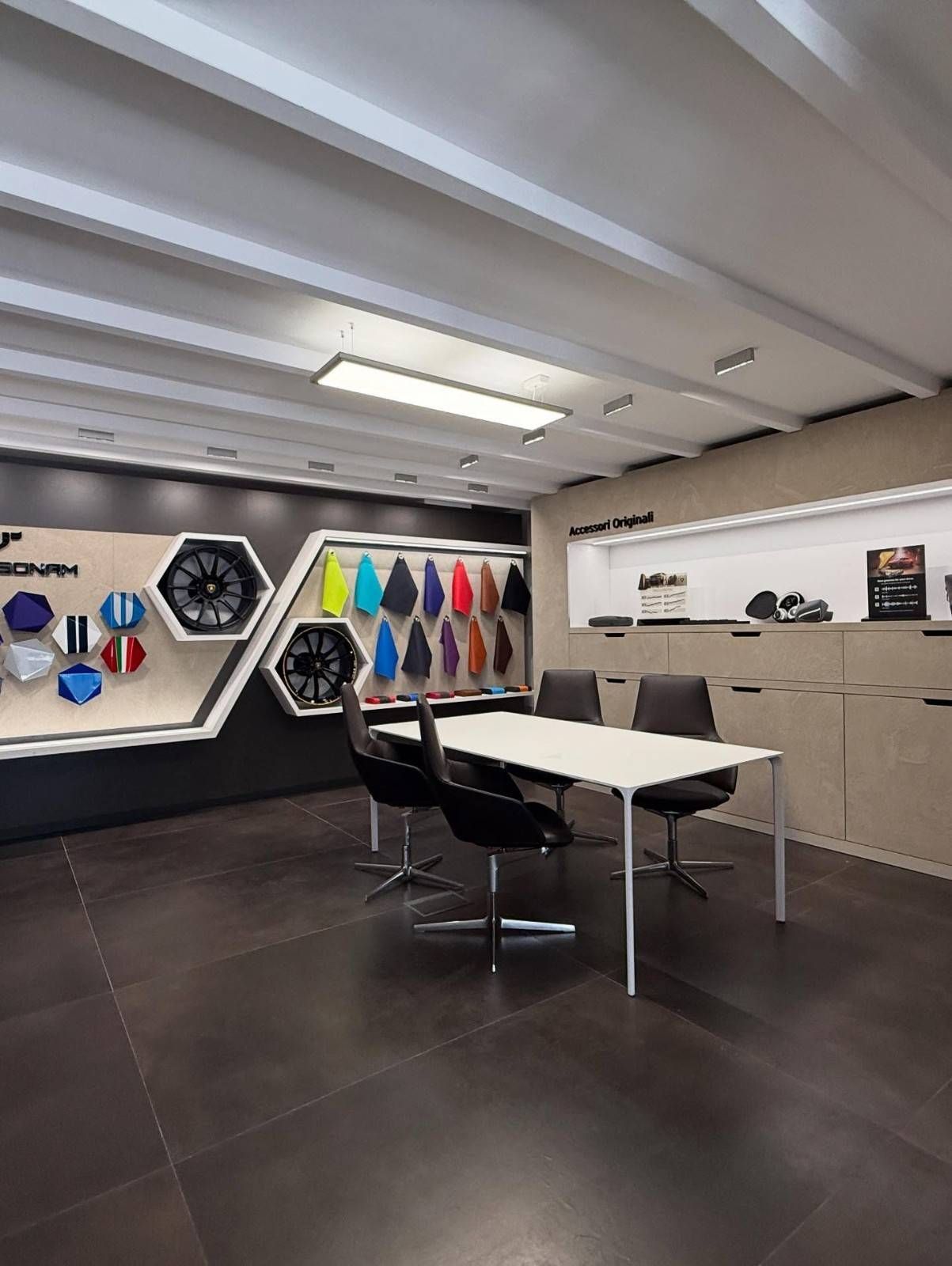 Taller de garaje moderno con mesa, sillas, herramientas montadas en la pared y una colorida exhibición de repuestos para automóviles.