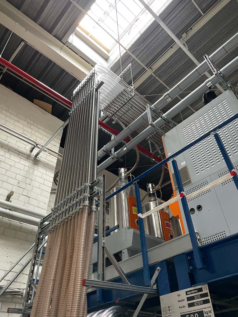 eine Maschine in einer Fabrik, aus der viele Rohre herauskommen - KID GmbH Anlagenbau in Bad Hersfeld