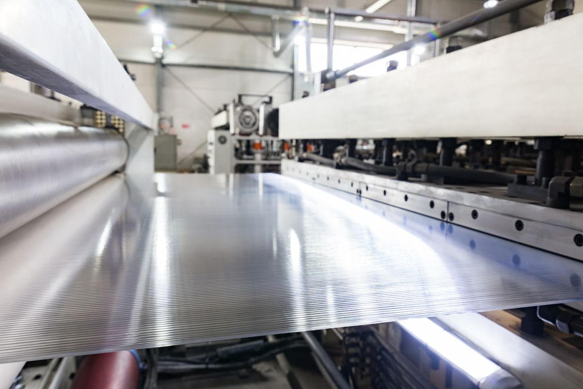 Eine Maschine schneidet in einer Fabrik ein Stück Metall - KID GmbH Anlagenbau in Bad Hersfeld