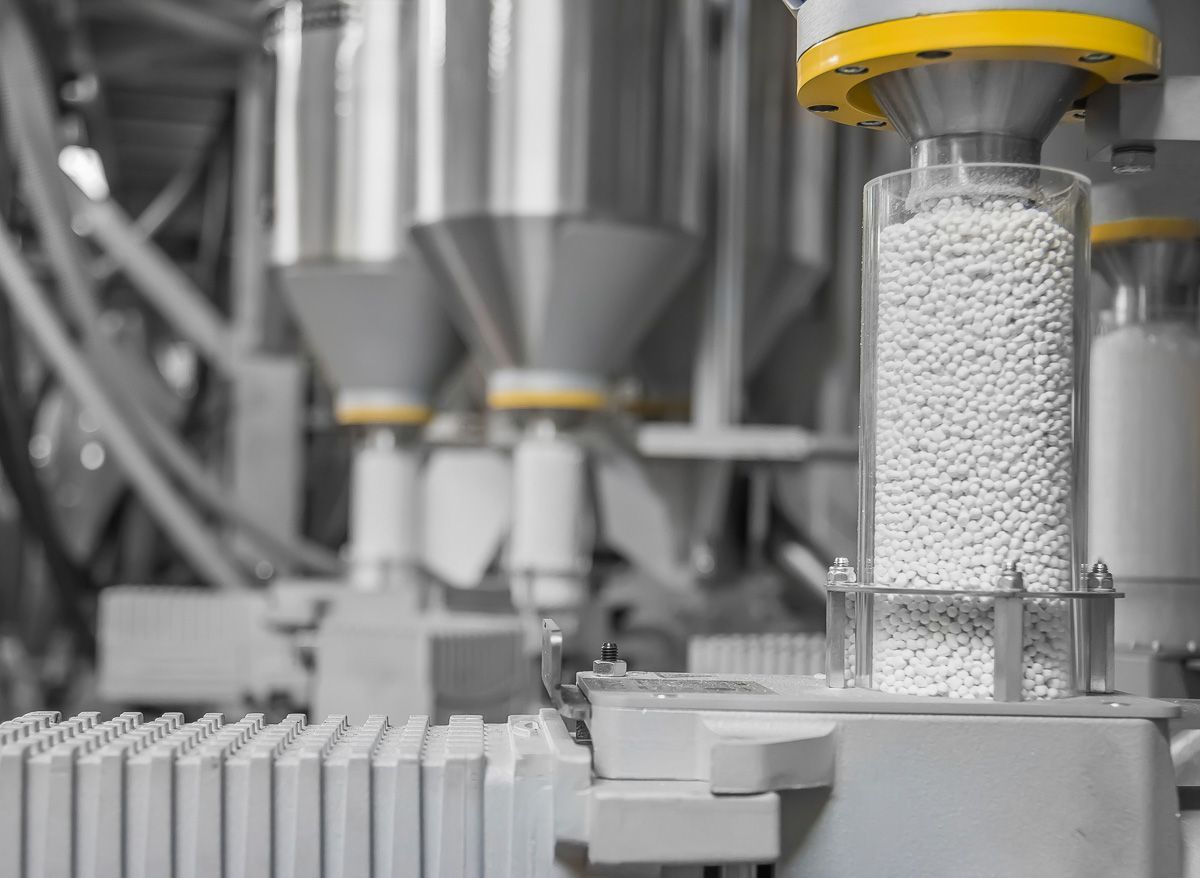 Eine Maschine füllt in einer Fabrik einen Behälter mit weißem Pulver - KID GmbH Anlagenbau in Bad Hersfeld