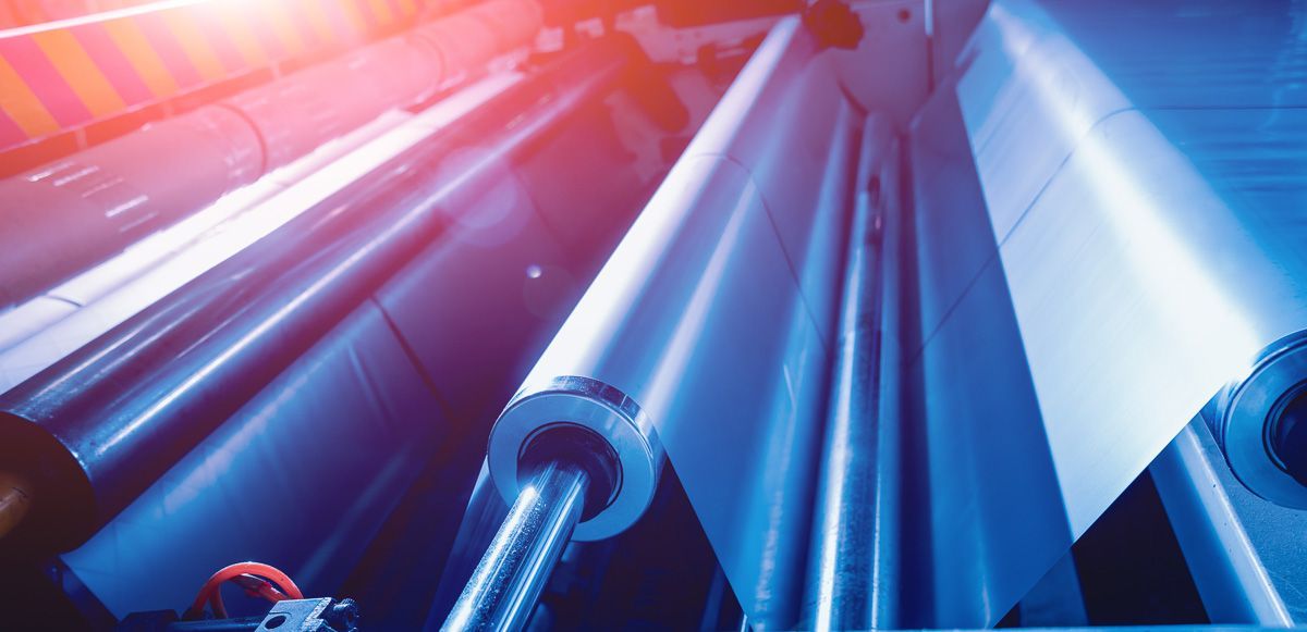 Eine Maschine stellt in einer Fabrik eine Papierrolle her - KID GmbH Anlagenbau in Bad Hersfeld