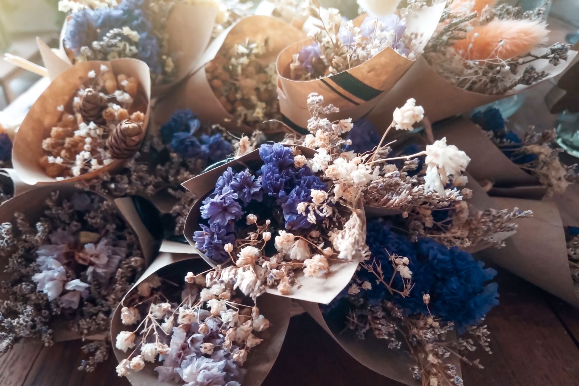 Bouquets de fleurs séchées assorties dans des tons pastel et bleus, arrangées ensemble.