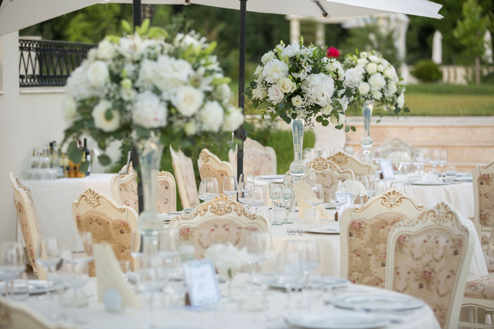 Réception de mariage élégante en plein air, avec centres de table floraux blancs.