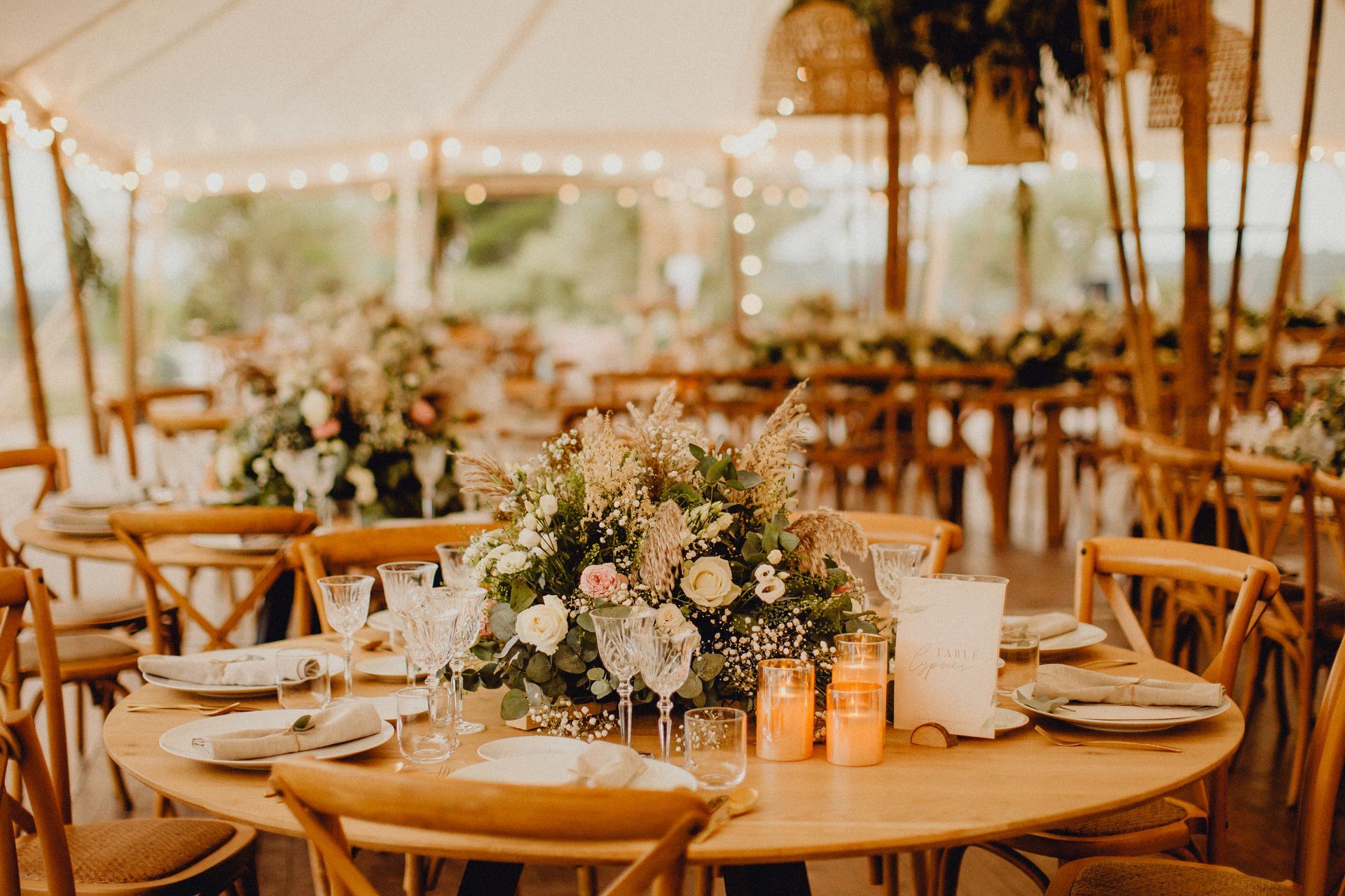 Table de réception de mariage rustique en plein air avec centre de table floral, bougies.