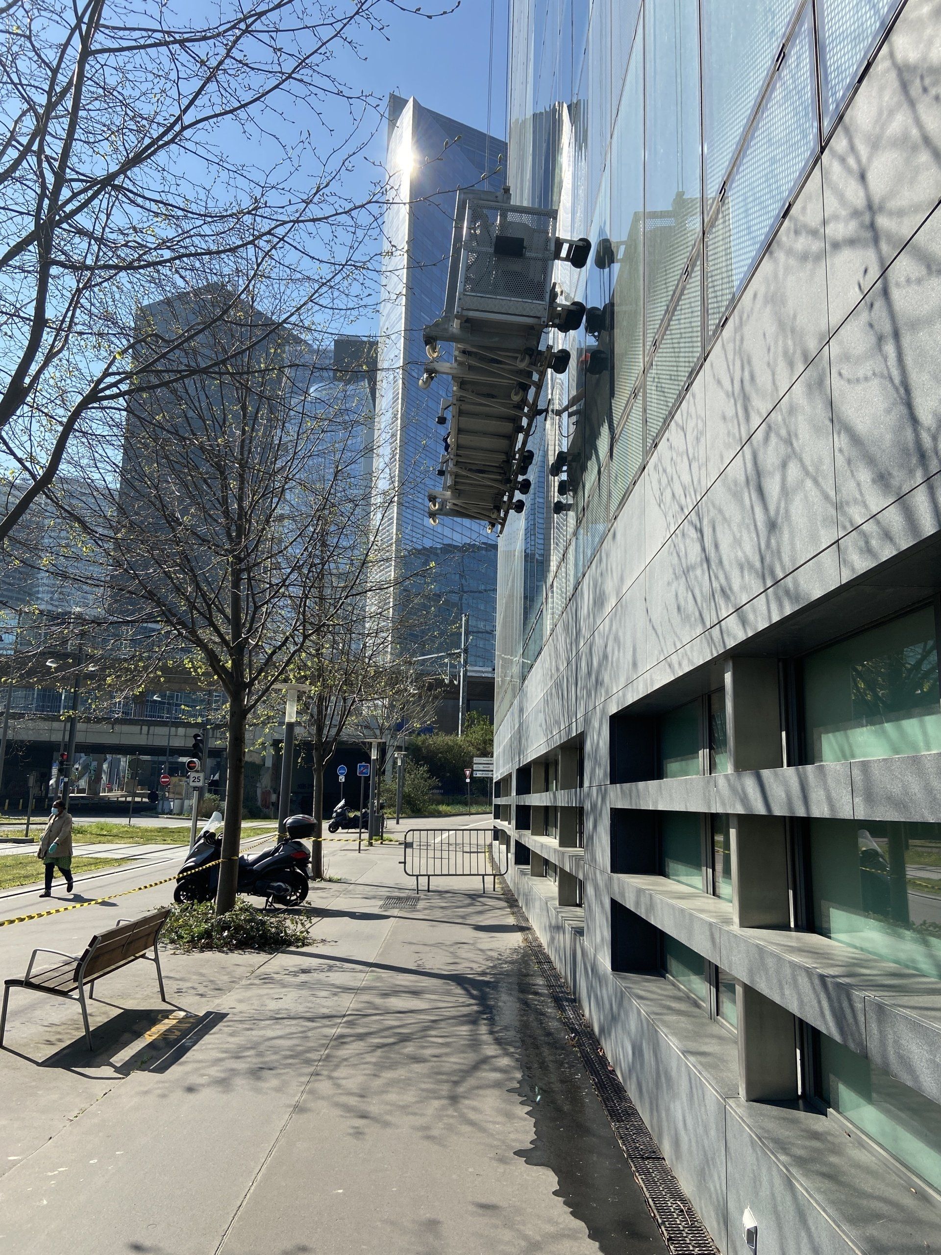 Trottoir à côté d'un immeuble moderne ; plateforme de lavage de vitres ; panorama urbain.
