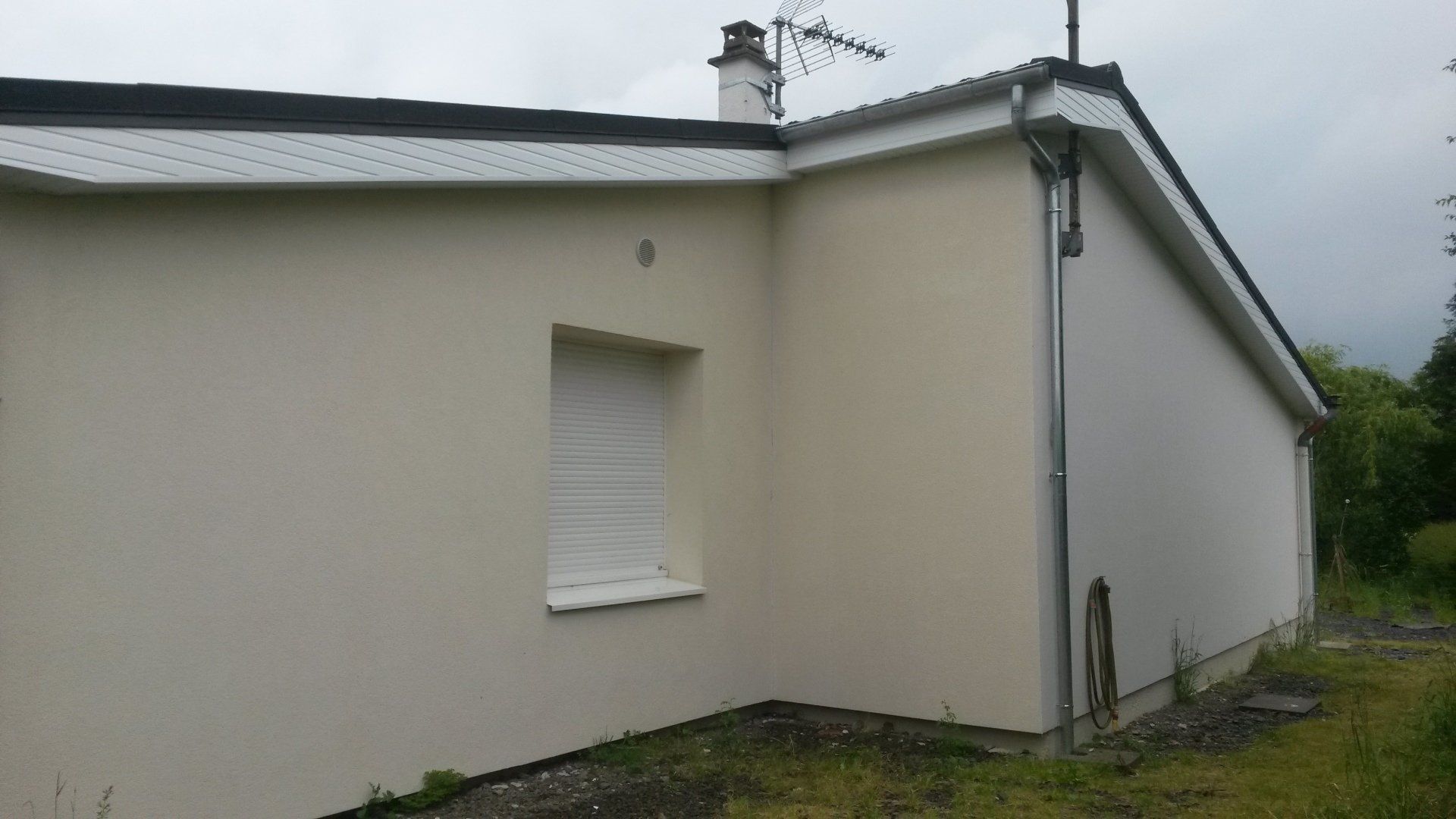 Une maison avec un volet roulant blanc.