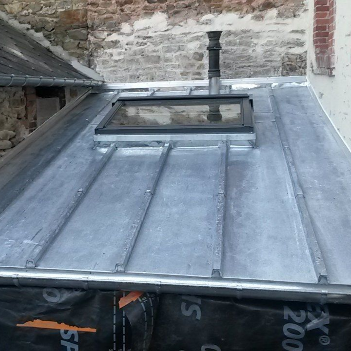 Une toiture en zinc et une fenêtre de toit.